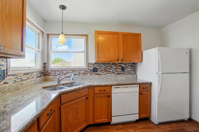 kitchen with white appliances, dark wood finished floors, decorative backsplash, and a sink