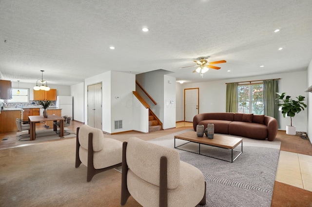 living area featuring recessed lighting, a textured ceiling, visible vents, and stairway