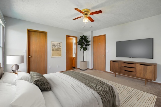 carpeted bedroom featuring ceiling fan, a textured ceiling, and connected bathroom
