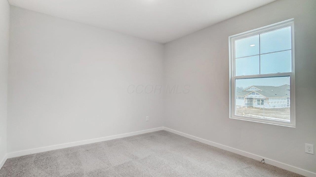 carpeted empty room with baseboards and plenty of natural light