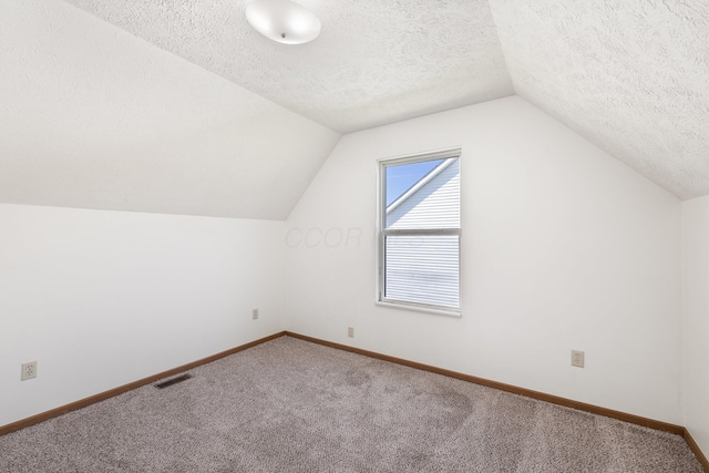 611 Sackman St, Mansfield, OH 44903 - bonus room featuring carpet flooring, a textured ceiling, baseboards, vaulted ceiling, and visible vents