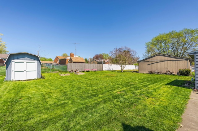 view of yard featuring fence, an outbuilding, and a shed
