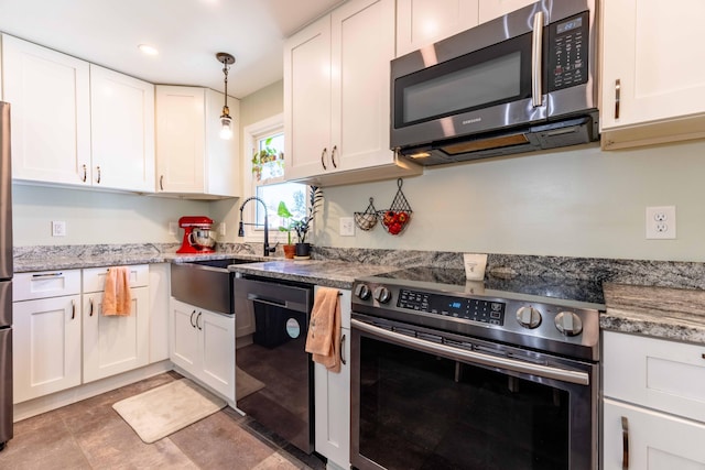 kitchen with hanging light fixtures, appliances with stainless steel finishes, and white cabinets