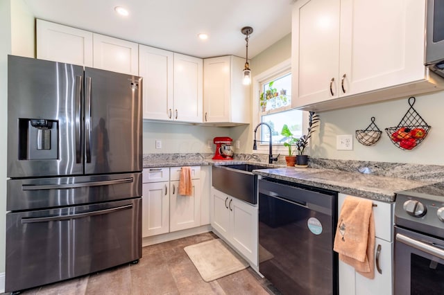 kitchen featuring a sink, appliances with stainless steel finishes, white cabinets, and light stone countertops
