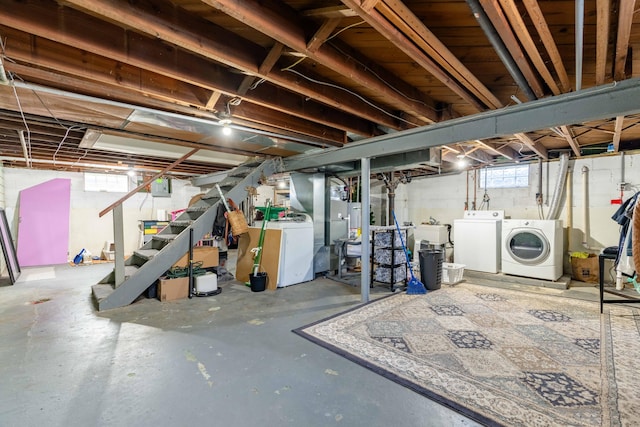 below grade area with washer and dryer, a sink, gas water heater, stairway, and electric panel