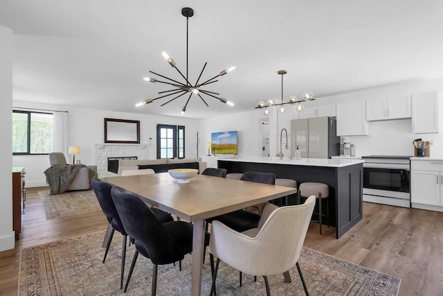 5300 Clark State Rd, Columbus, OH 43230 - dining area featuring a fireplace, wood finished floors, a chandelier, and a wealth of natural light