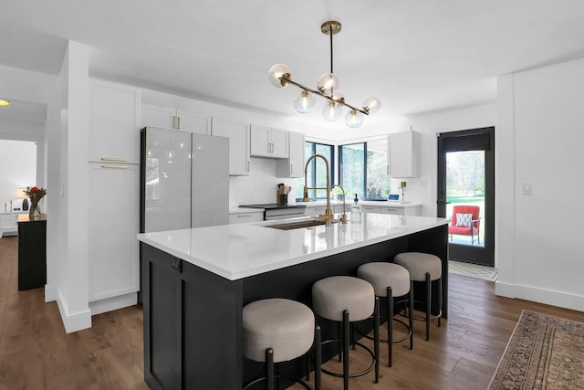 5300 Clark State Rd, Columbus, OH 43230 - kitchen featuring an island with sink, light countertops, white cabinets, a sink, and dark wood finished floors