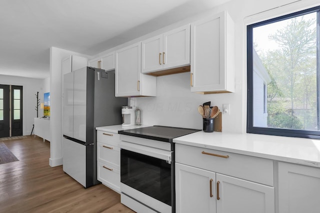5300 Clark State Rd, Columbus, OH 43230 - kitchen featuring freestanding refrigerator, electric range, white cabinetry, and light wood-style flooring