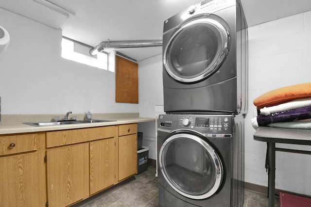 895 Janet Dr, Columbus, OH 43224 - laundry area featuring stacked washer and clothes dryer, a sink, and cabinet space