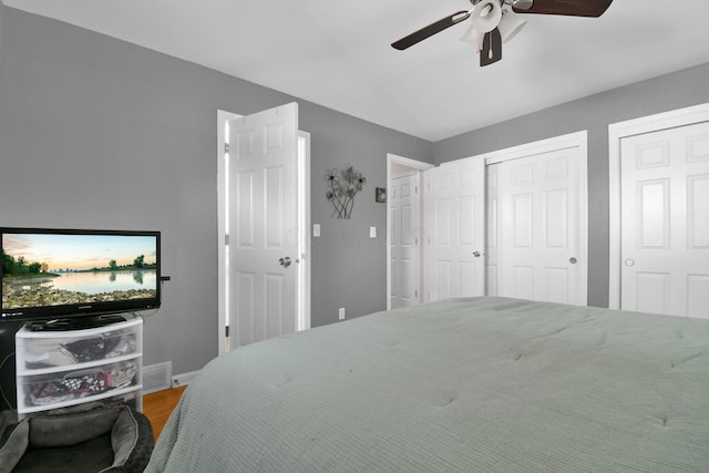 895 Janet Dr, Columbus, OH 43224 - bedroom featuring ceiling fan, visible vents, wood finished floors, baseboards, and multiple closets
