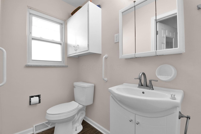 895 Janet Dr, Columbus, OH 43224 - bathroom featuring visible vents, wood finished floors, baseboards, vanity, and toilet