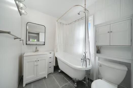233 Girard Rd, Columbus, OH 43214 - bathroom featuring a freestanding bath, tile patterned flooring, curtained shower, vanity, and toilet