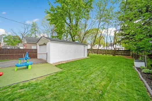 233 Girard Rd, Columbus, OH 43214 - view of yard with a detached garage, an outbuilding, and a fenced backyard