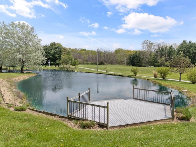 view of dock featuring a lawn and a water view