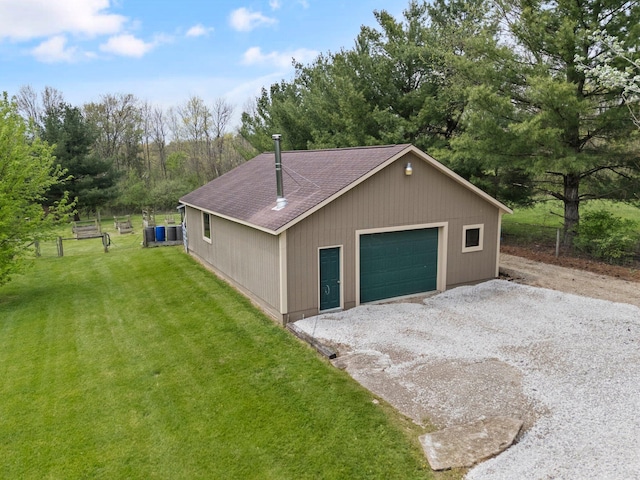 exterior space featuring a garage, fence, gravel driveway, a shingled roof, and a yard