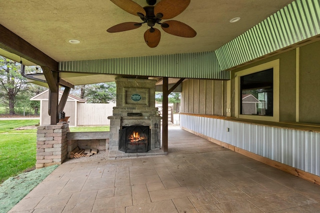 view of patio with an outdoor stone fireplace and ceiling fan