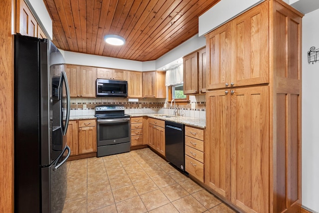 kitchen with light stone counters, a sink, wooden ceiling, backsplash, and black appliances