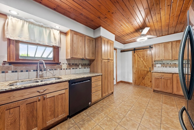kitchen with light tile patterned flooring, a barn door, a sink, backsplash, and dishwashing machine