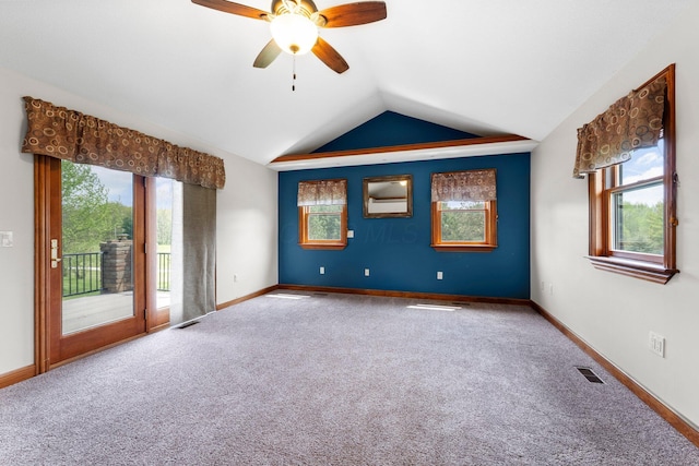 carpeted empty room featuring visible vents, a ceiling fan, baseboards, and vaulted ceiling