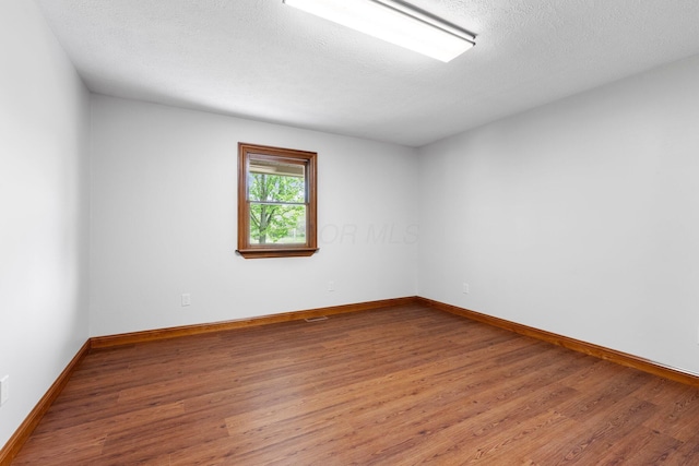 empty room featuring baseboards and wood finished floors