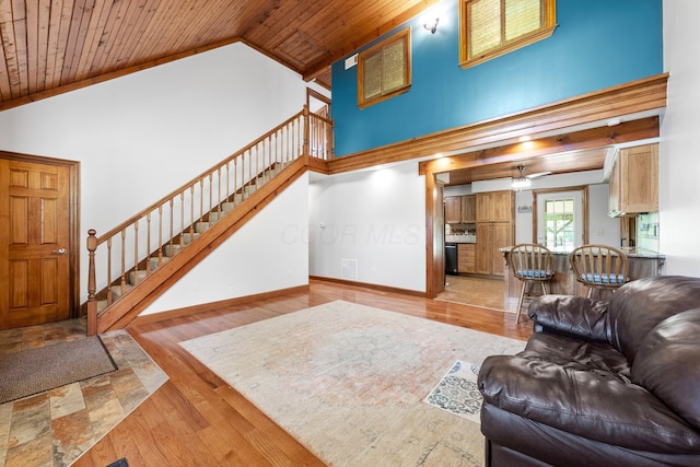 living room featuring high vaulted ceiling, stairs, a ceiling fan, wooden ceiling, and wood finished floors