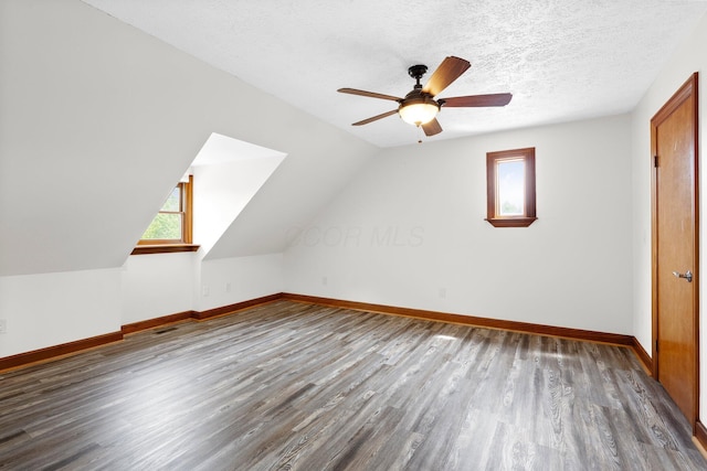 bonus room with baseboards, a ceiling fan, wood finished floors, and lofted ceiling