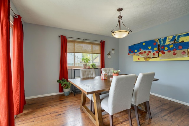 dining room featuring baseboards and hardwood / wood-style flooring