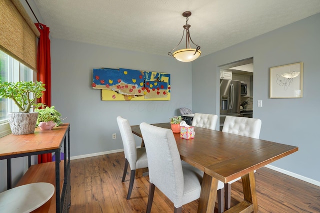 dining room with wood-type flooring and baseboards