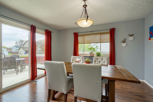 dining area with visible vents, wood finished floors, and a wealth of natural light