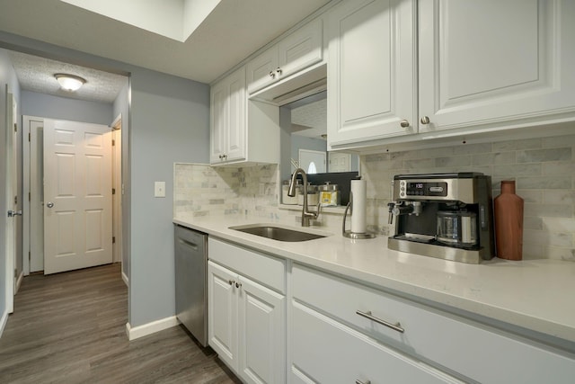 kitchen with a sink, tasteful backsplash, stainless steel dishwasher, and white cabinets