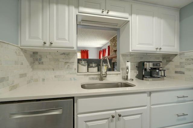 kitchen featuring a sink, tasteful backsplash, white cabinets, and dishwasher