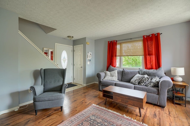 living room with baseboards, wood-type flooring, and stairs