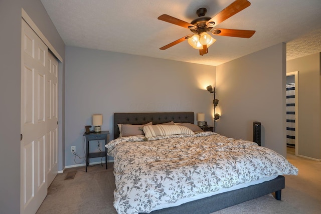 carpeted bedroom featuring baseboards, visible vents, ceiling fan, and a closet