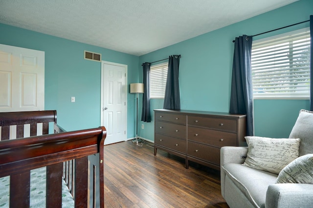 bedroom with visible vents, baseboards, and dark wood-type flooring