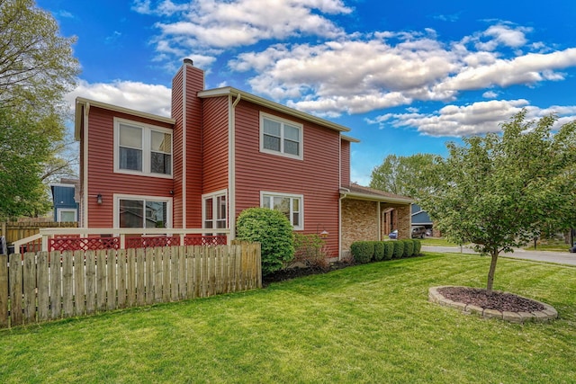 view of home's exterior featuring a yard, fence, and a chimney