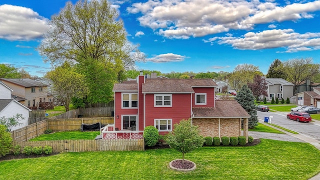 rear view of house with roof with shingles, fence, a residential view, a chimney, and a lawn