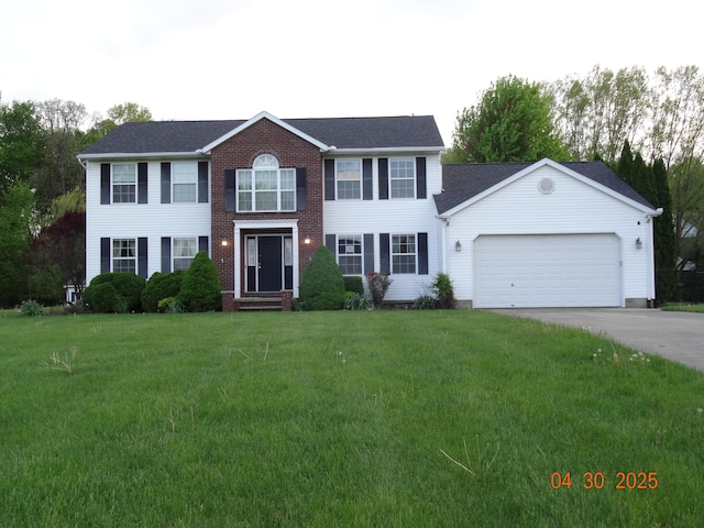 colonial-style house featuring brick siding, a garage, driveway, and a front yard