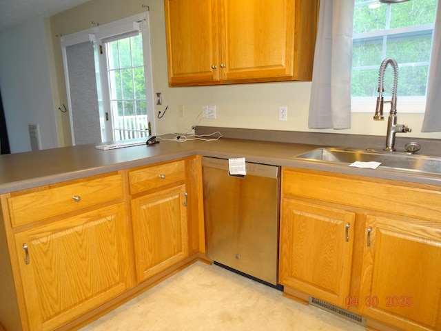 kitchen featuring a peninsula, visible vents, a sink, and dishwasher