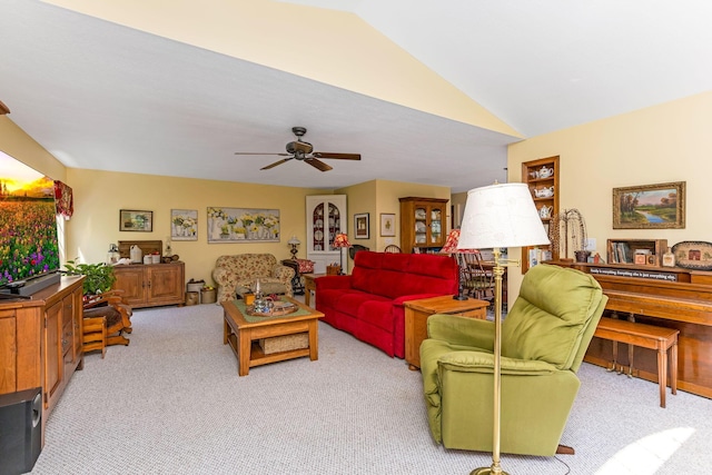 carpeted living room with ceiling fan and vaulted ceiling