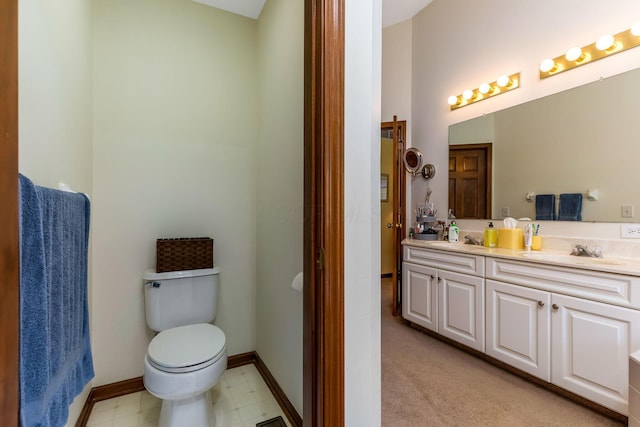 bathroom featuring double vanity, toilet, tile patterned floors, and a sink