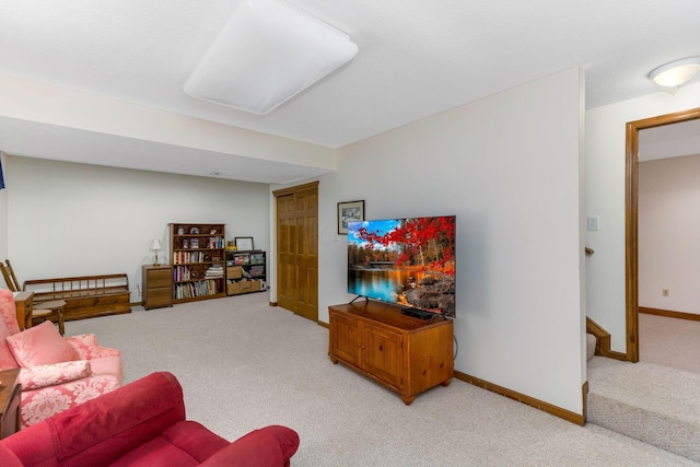 living area featuring baseboards and carpet flooring