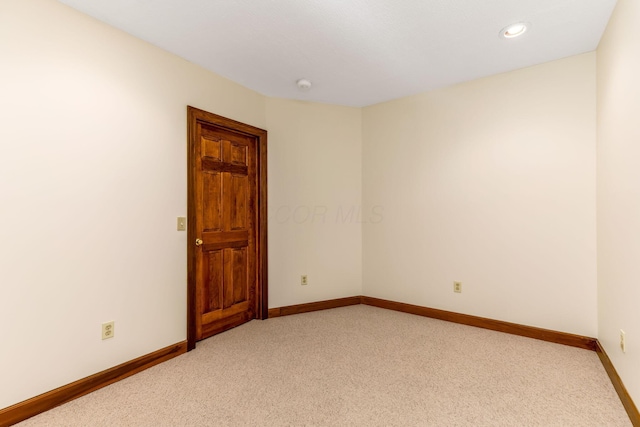 unfurnished room with baseboards, recessed lighting, and light carpet