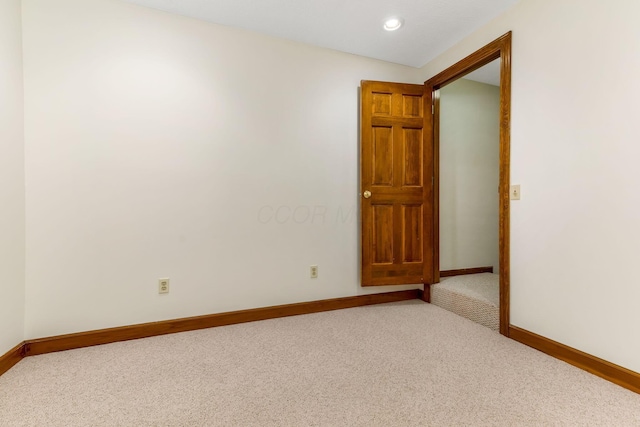 carpeted spare room featuring baseboards