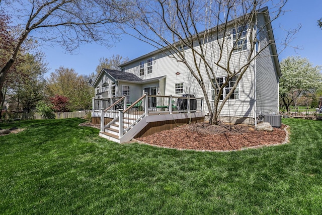 rear view of house with central AC, a wooden deck, and a yard