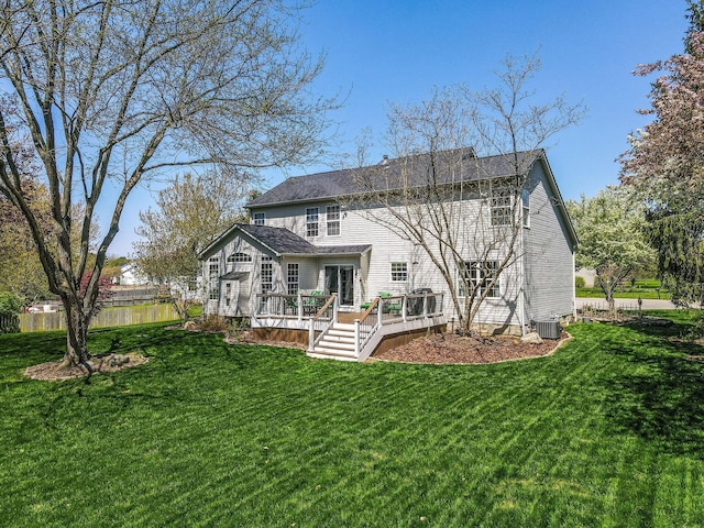 rear view of house with roof with shingles, central AC unit, a wooden deck, fence, and a yard