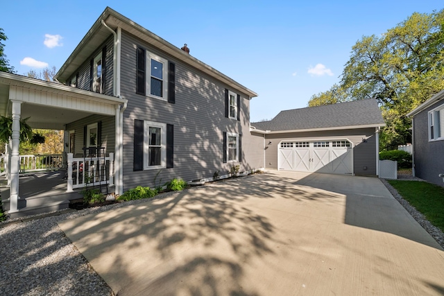 view of property exterior with an outdoor structure, covered porch, a chimney, an attached garage, and driveway