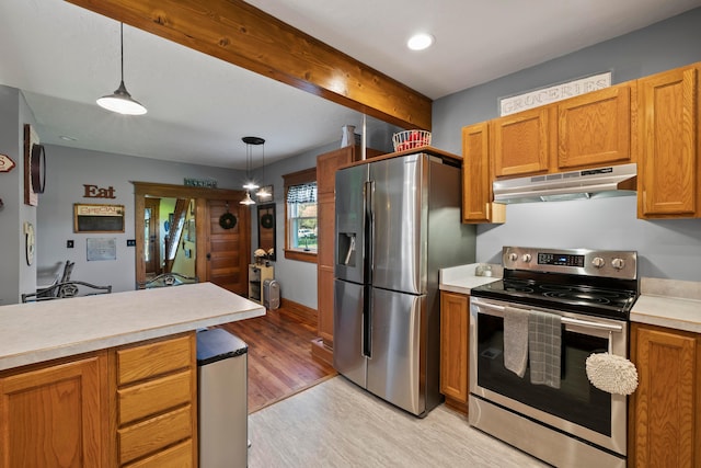 kitchen with appliances with stainless steel finishes, light wood-style floors, light countertops, under cabinet range hood, and pendant lighting