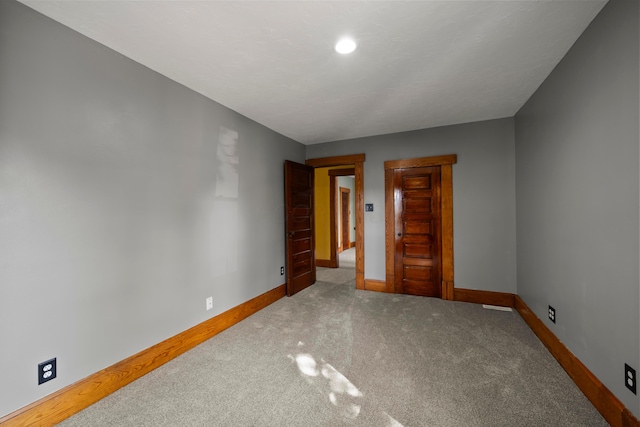 empty room featuring baseboards and carpet flooring