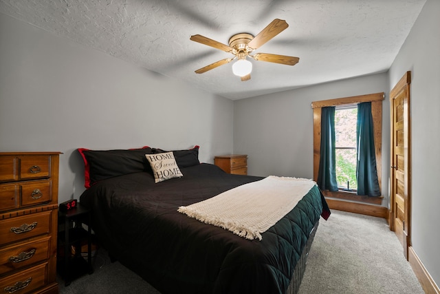 bedroom with a textured ceiling, light colored carpet, and ceiling fan
