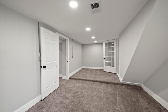 finished below grade area featuring visible vents, carpet flooring, baseboards, and recessed lighting